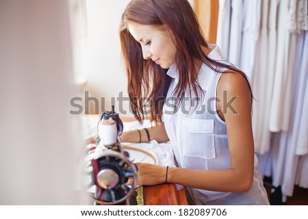 woman sewing on old sewing machine (focus on her eyes)