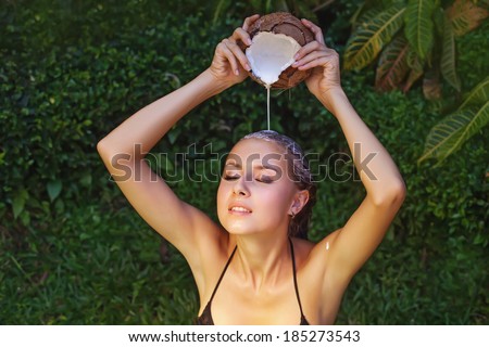 Woman washing her hair with the pure coconut milk