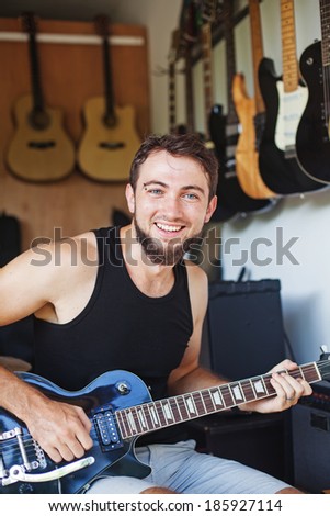man checking his new guitar in the music shop