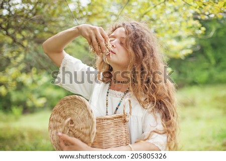 Beautiful woman smelling aromatic dried herbs (soft focus on her eyes)
