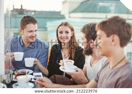 people enjoying coffee together with friends (focus on woman\'s eyes)
