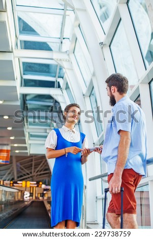 Beautiful young flight attendant checking documents in airport