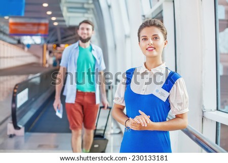 Beautiful young flight attendant in the airport (tourist walking on a background)