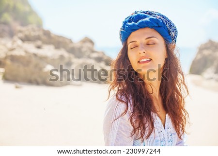Woman with closed eyes with a cloth wrapped around her head in a turban style