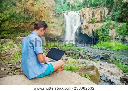 man using his laptop in a jungle