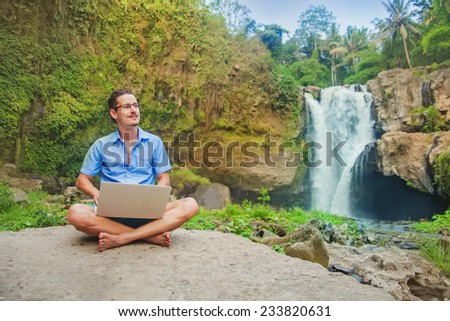 successful man with laptop in a jungle