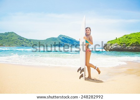 woman with a surf board on a stunning beach
