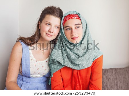 friendship of the religions concept: muslim and christian girl together