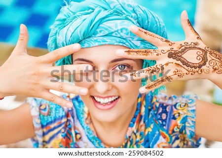 Woman showing her hands painted with henna