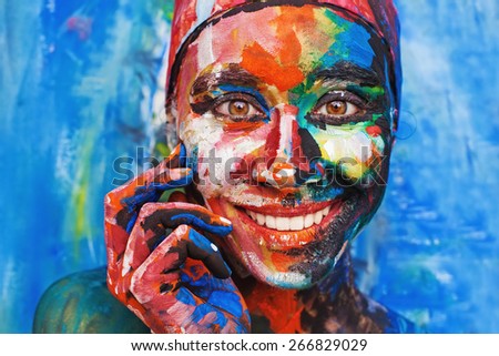 Living painting - smiling woman completely covered with thick paint