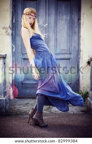 Young woman in the city in long violet dress