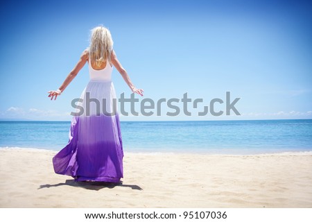 Young blonde woman standing back on the beach, bali
