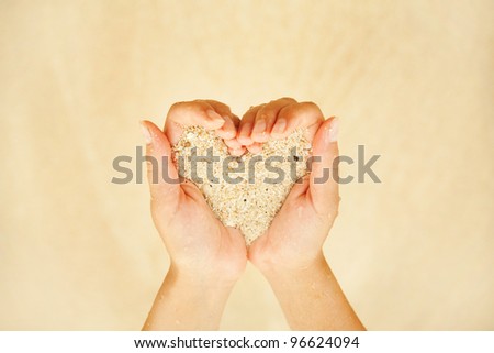 sand in hands in heart shape