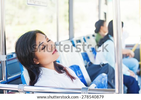 overworked asian office worker sleeping in a bus