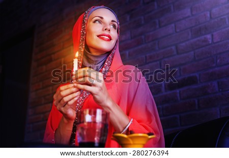 Beautiful muslim woman waiting for an evening time to take Iftar - evening meals of Ramadan month