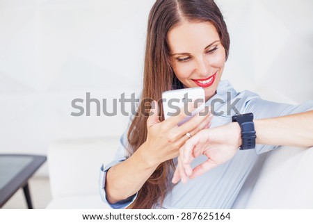 woman using wearable smart watch and mobile phone together