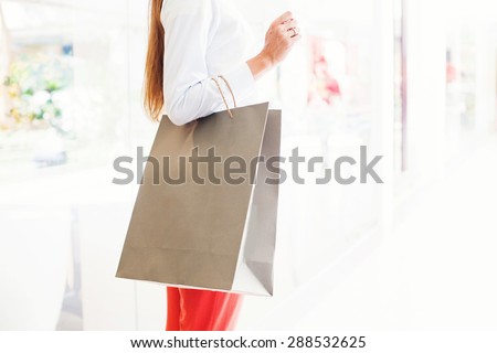 faceless photograph of woman holding a blank paper shopping back (mock up to paste a logo)