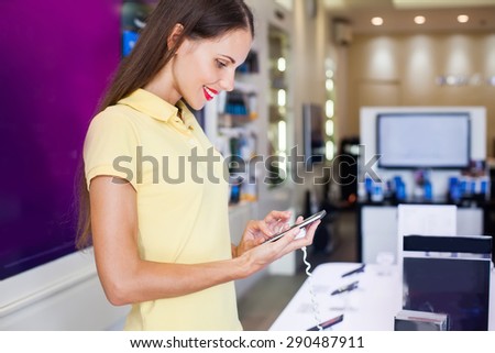 woman choosing a new mobile phone in a shop