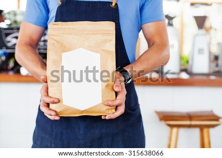 Package design template mockup. Man holding blank coffee package