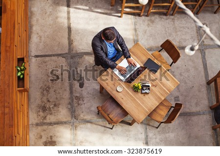 top view of a man working on his laptop in beautiful office interior
