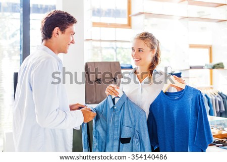 shop assistant helping to choose clothes in a store