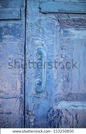 the metal door handle on an old semi-drunk wooden door