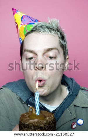 Man blows out his birthday cupcake