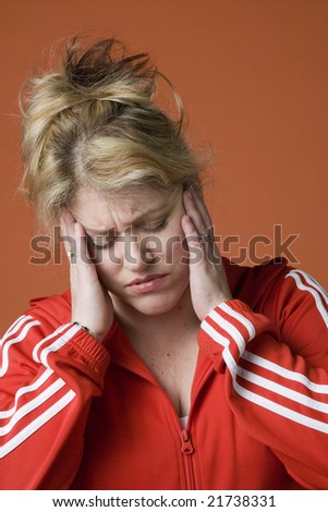 Middle-aged woman with a headache on a plain orange background