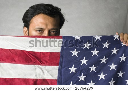 Mexican man hiding behind American Flag