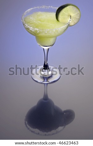 Frozen Margarita mixed drink with lime slice garnish on plain background with reflection