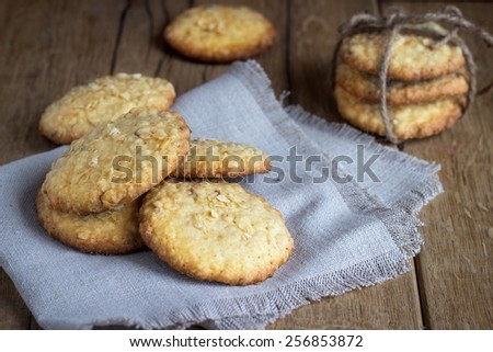 oatmeal cookies on white linen napkin on wooden table. Chocolate chip cookies shot on coffee colored cloth, closeup.