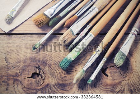 Paint brushes for painting on a wooden background toning