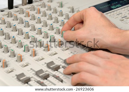 Audio engineer\'s hands working on a mixer