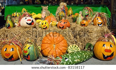 Cheerful looking painted pumpkins on straw, nicely arranged for sale