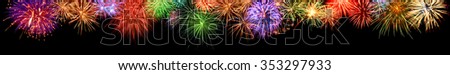 Gorgeous multi-colored fireworks as an extra wide panoramic border on black background, ideal for New Year or other celebration events