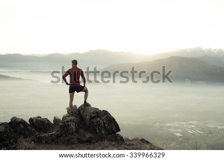 Man at the top of a mountain looking the landscape