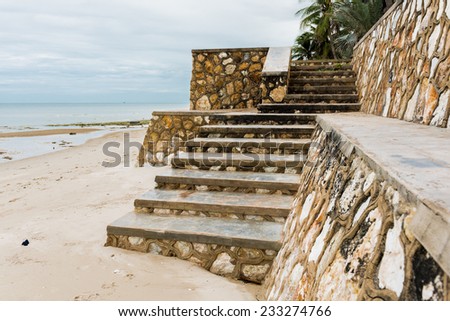 Weathered concrete stairs with mold, faded paint.,crumbling. on the beach