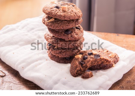 Chocolate chip cookies on napkin on wooden table. Stacked chocolate chip cookies close up