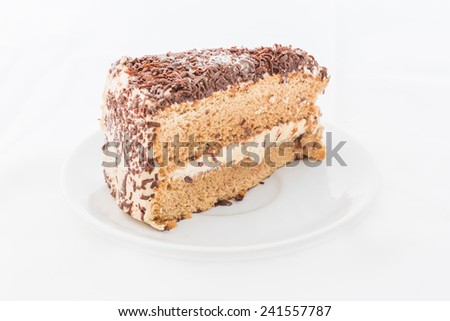 Chocolate cake slice with curl on white dish. white background