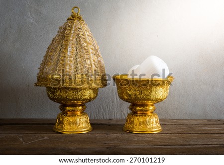 still life of Group of Thailand Gold tray with pedestal with The cover is made of lace on wooden table with grunge background. Thailand Culture Wedding Ceremony