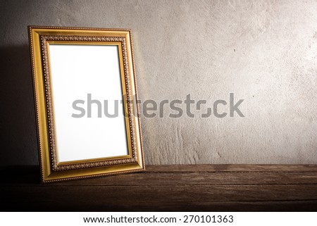 still life of luxurious photo frame on wooden table over grunge background. vintage tone