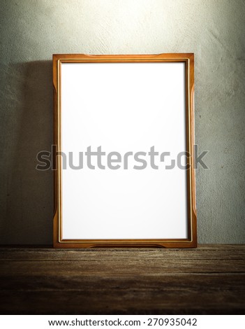 still life of photo frame on wooden table over grunge background. vintage tone