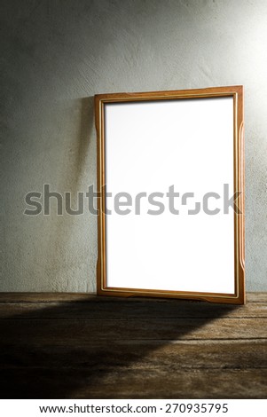 still life of photo frame on wooden table over grunge background. vintage tone