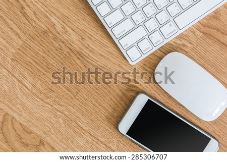 overhead of office table with computer keyboard and mouse,  and smartphone. copy space