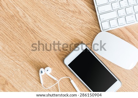 overhead of office table with computer keyboard and mouse,  and smartphone. copy space