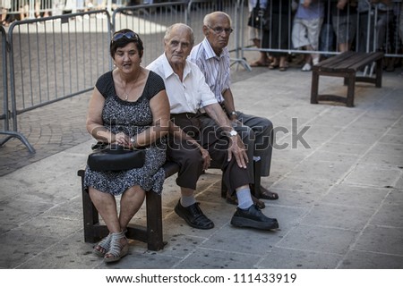 VALLETTA, MALTA - AUG 25 - Three senior supporters share a bench during the state funeral of former Prime Minister of Malta Dom Mintoff in Valletta on 25 August 2012