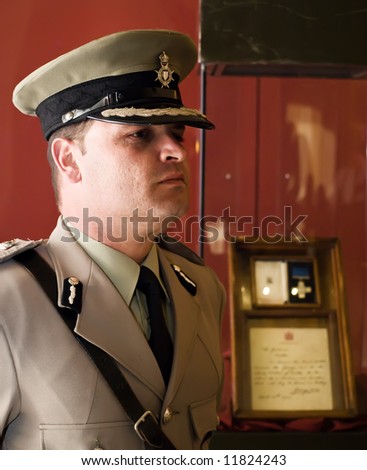 Man in military or police uniform in Malta with original George Cross medal in background