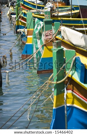 Rudders of traditional fishing boats of Malta in the fishing village of Marsaxlokk lined up at quayside