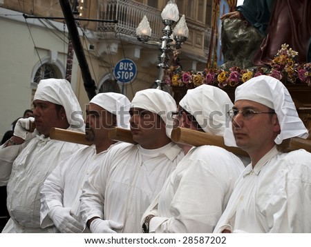 LUQA, MALTA - APR10 - Men in hooded mask carrying a statue during a procession in luqa, Malta April 10, 2009
