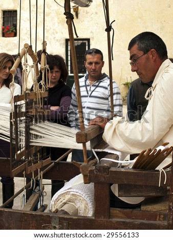 MDINA, MALTA - APR 19 : A weaver uses medieval tools to produce cloth April 19, 2009 in Mdina, Malta.